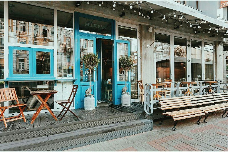 A café storefront with outdoor seating and string lights over the entrance.
